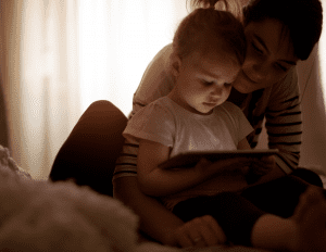 A young child on tech with her parent 