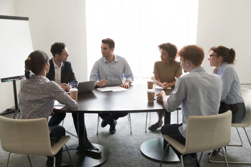 A group of people talking around a table