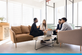 a woman talking to a group in a comfortable office space