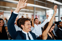 A group in office with hands raised.