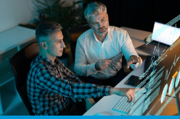 Two men reviewing data on a screen.